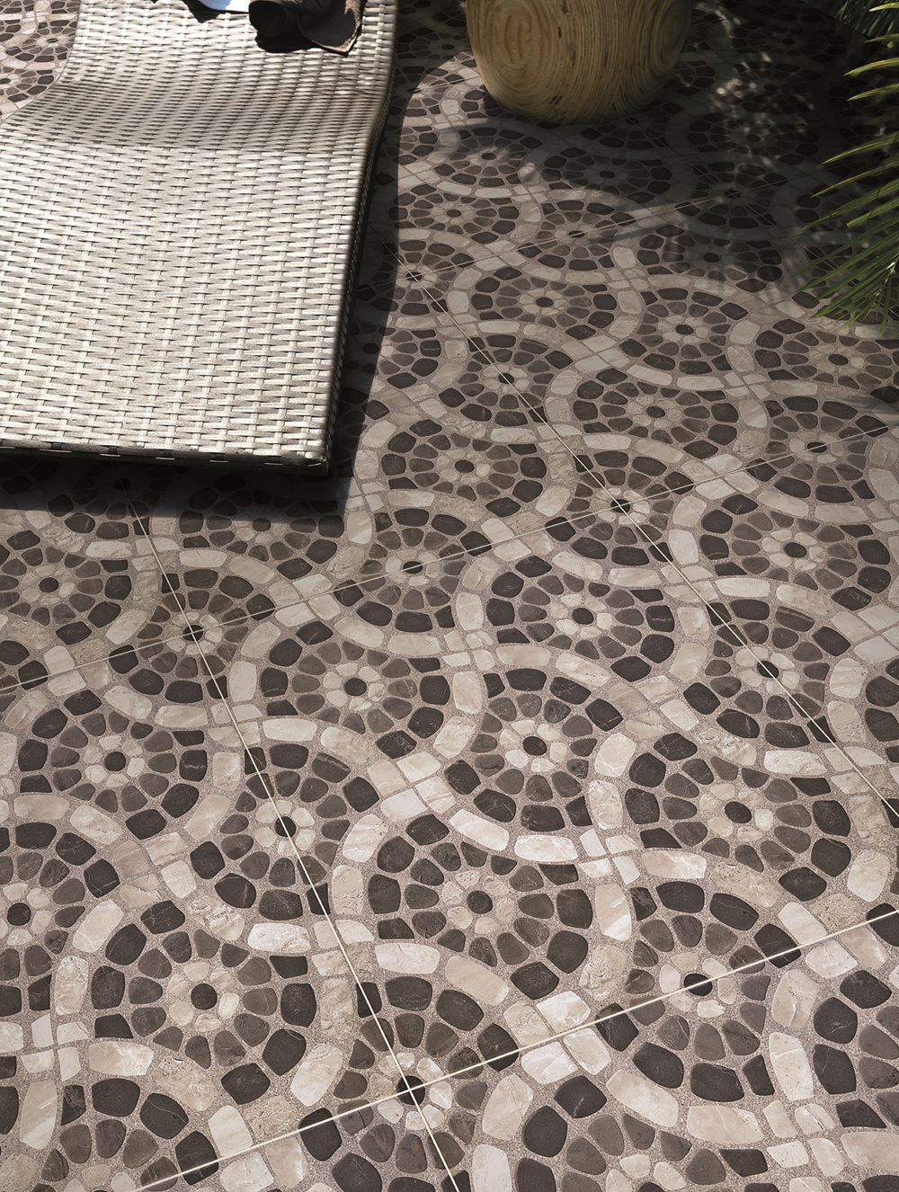 Close em piso de área externa que reproduz pedras em mosaico